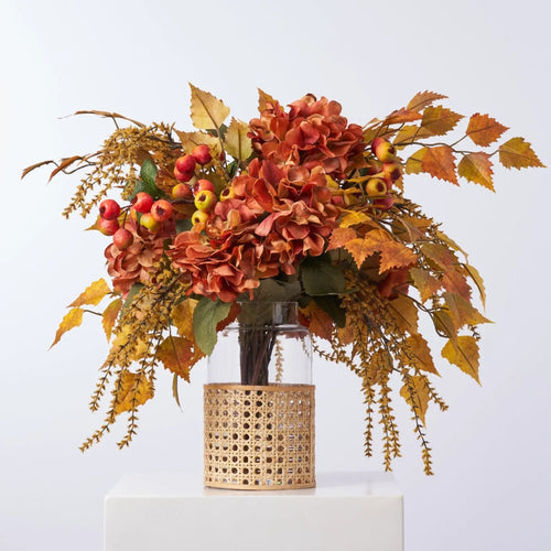 Golden Hour Fall Hydrangea, Birch Leaf, Orange Crater Berry & Yellow Astilbe Water Illusion Arrangement in Rattan Vase