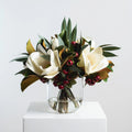 Holiday White Magnolia, Red Crabapple & Needle Leaf Eucalyptus Christmas Floral Arrangement Centerpiece in Glass Vase